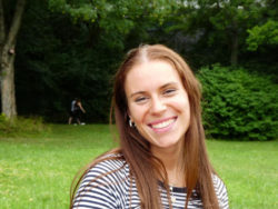 Auf dem Foto ist die Kandidatin Morgane Henninger lachend vor einer grünen Wiese zu sehen.