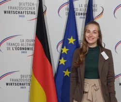 Sarah Heier vor einer deutschen, einer französischen und einer europäischen Flagge