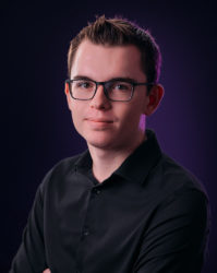 Ein Passfoto von Loïc Kuntz mit dunklem Hintergrund
