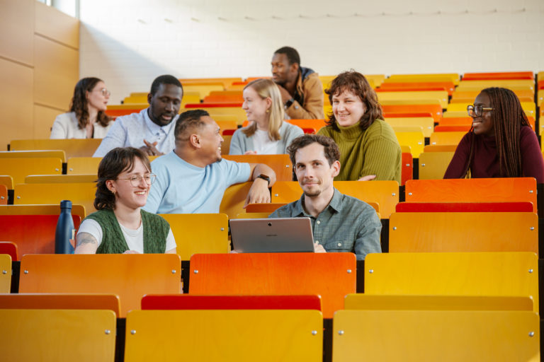 Sur la photo, on voit des étudiant·es dans un amphithéâtre de l'université